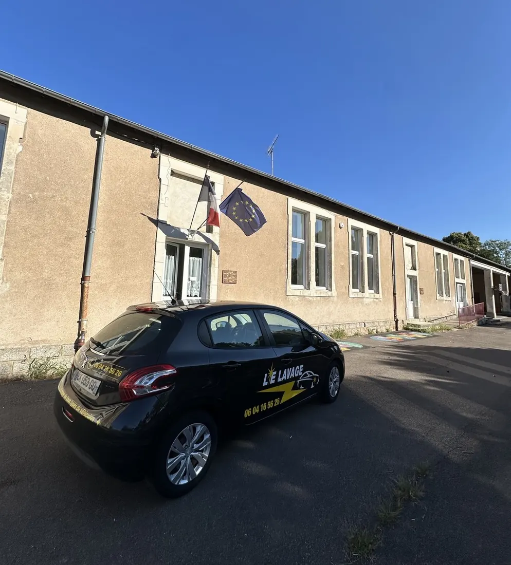 Le véhicule de service floqué Le Lavage 89, garé devant un bâtiment