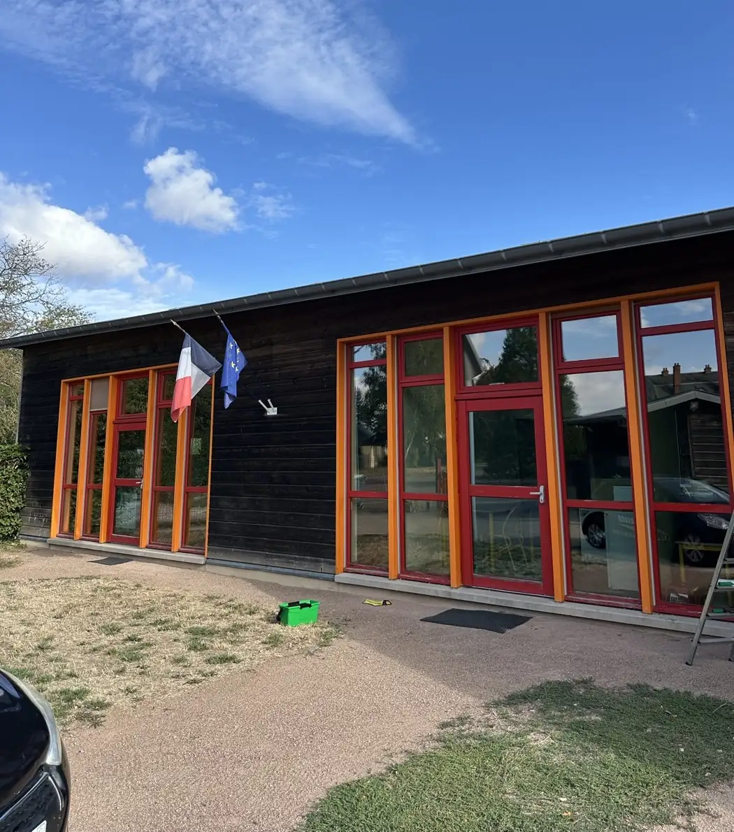 Façade d'un bâtiment à longues baies vitrées après nettoyage